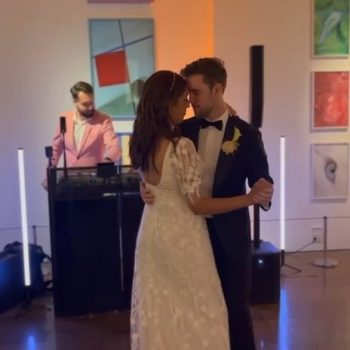 Bride and groom sharing their first dance on the wedding dance floor with romantic lighting.