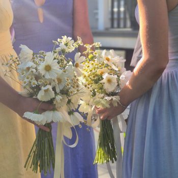 Bridesmaid holding a colorful wedding flower bouquet at a ceremony