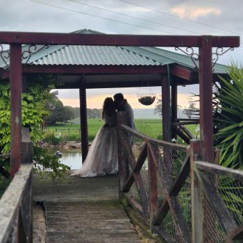Bride and groom posing outdoors with a stunning sky in the background