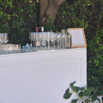 Wedding beverage station with drinks, glassware, and decorative display