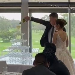 Joel and Narin celebrating with a champagne tower at their event.