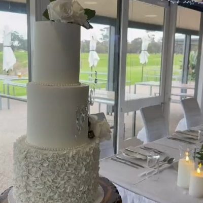 Elegant three-tier white wedding cake with minimal, modern styling.