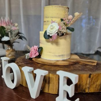 Elegant wedding cake displayed at the reception with floral décor