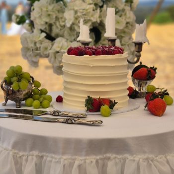 Wedding cake topped with fresh berries.