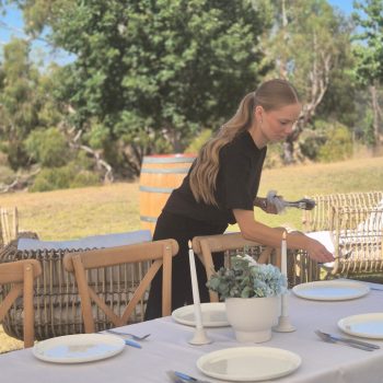 Wedding caterer setting up guest table for the event.