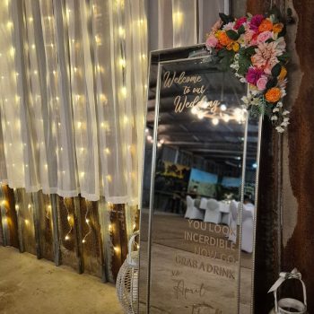Welcome mirror décor at a wedding, featuring elegant calligraphy and floral accents